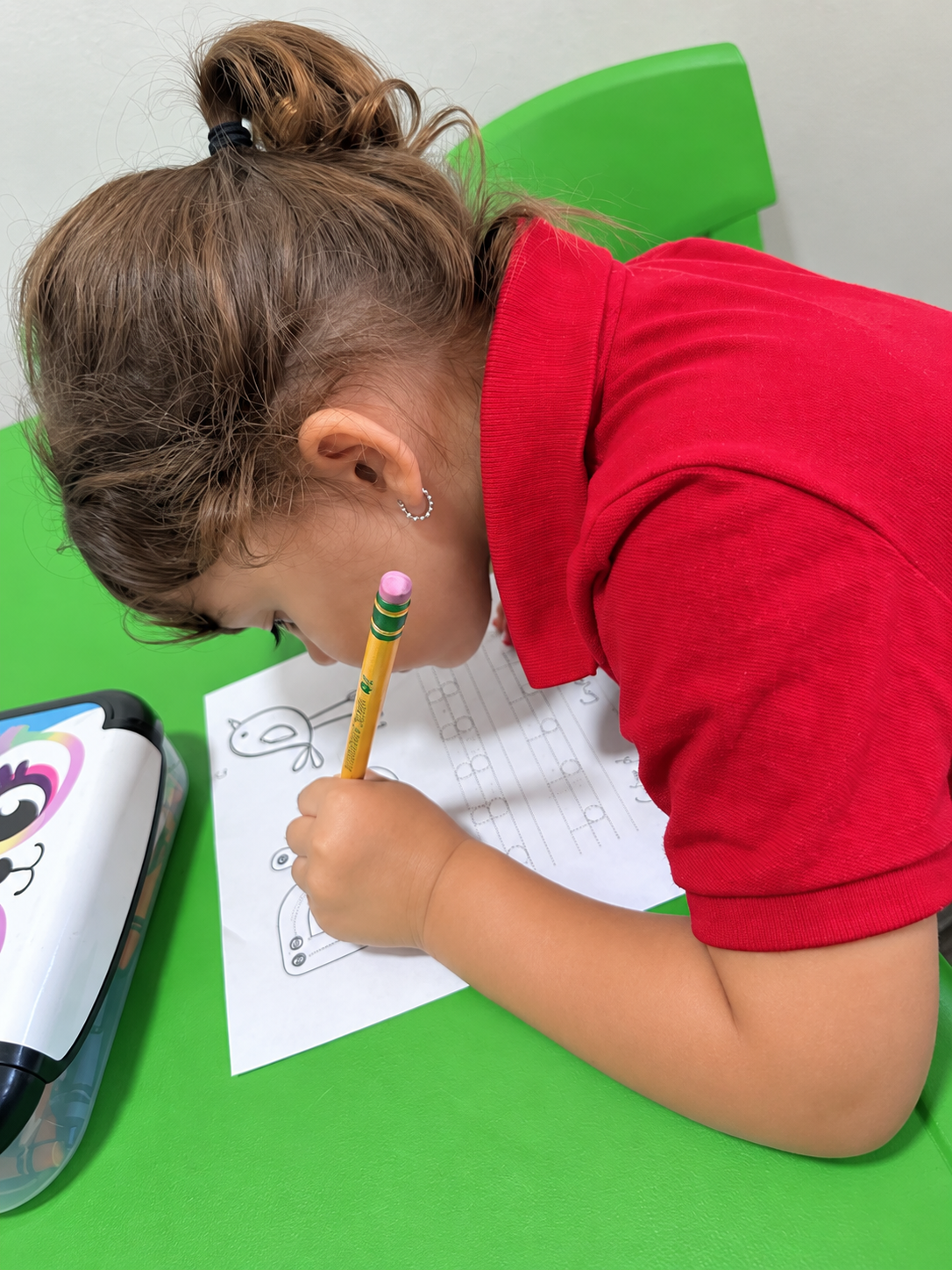 A child practicing writing at Little Learners